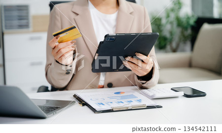 businesswoman hand using smart phone, tablet payments and holding credit card online shopping, omni channel, digital tablet businesswoman hand using smart phone, tablet payments and holding credit card online shopping, omni channel, digital tablet 134542111