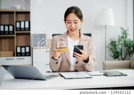 businesswoman hand using smart phone, tablet payments and holding credit card online shopping, omni channel, digital tablet 134542112