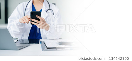 Medical technology concept. Asian Doctor working with mobile phone and stethoscope in office 134542590