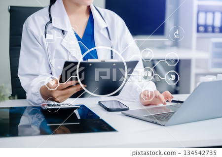 Doctor works with mobile devices on the Internet in the office. on hologram modern virtual icon 134542735