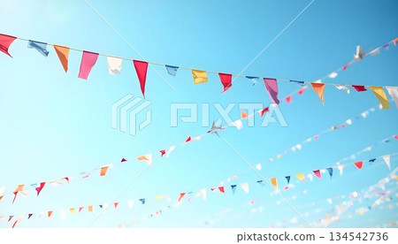 Festive bunting flags in various colors flying in the sky, perfect for summer celebrations and outdoor gatherings Festive bunting flags in various colors flying in the sky, perfect for summer celebrations and outdoor gatherings 134542736