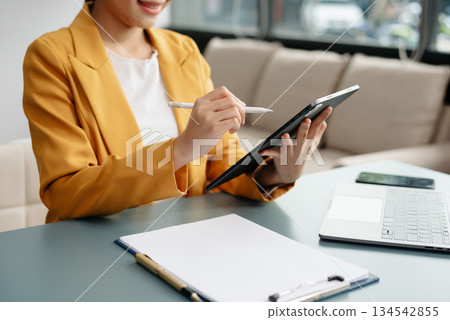 Businesswoman hand using laptop, tablet and smartphone in office. Digital marketing media mobile app and discussing plan new start up project. Businesswoman hand using laptop, tablet and smartphone in office. Digital marketing media mobile app and discussing plan new start up project. 134542855