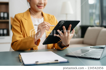 Businesswoman hand using laptop, tablet and smartphone in office. Digital marketing media mobile app and discussing plan new start up project. 134542856
