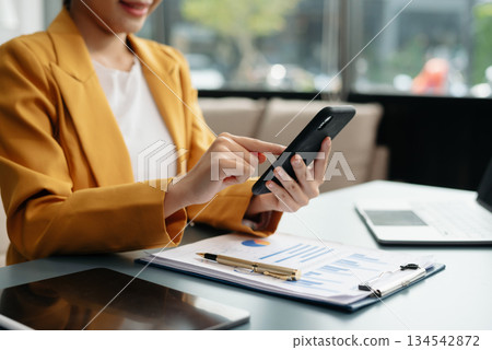 Business woman working with laptop and documents on his desk new start up project. Finance task. Business woman working with laptop and documents on his desk new start up project. Finance task. 134542872