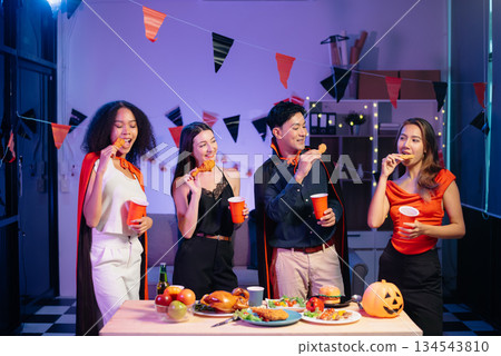 Halloween party with friends in costumes, enjoying drinks, food, and festive decorations. Perfect for autumn gatherings Halloween party with friends in costumes, enjoying drinks, food, and festive decorations. Perfect for autumn gatherings 134543810