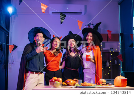 Halloween party with friends in costumes, enjoying drinks, food, and festive decorations. Perfect for autumn gatherings 134543814