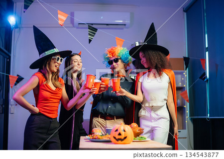 Halloween party with friends in costumes, enjoying drinks, food, and festive decorations. Perfect for autumn gatherings Halloween party with friends in costumes, enjoying drinks, food, and festive decorations. Perfect for autumn gatherings 134543877