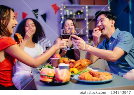 Celebration with friends enjoying food, drinks, and laughter at a lively house party. Perfect for themes of joy, togetherness, Celebration with friends enjoying food, drinks, and laughter at a lively house party. Perfect for themes of joy, togetherness, 134543947