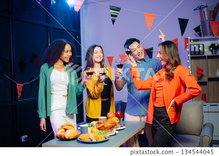 Celebration with friends enjoying food, drinks, and laughter at a lively house party. Perfect for themes of joy, togetherness, Celebration with friends enjoying food, drinks, and laughter at a lively house party. Perfect for themes of joy, togetherness, 134544045
