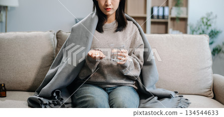 woman holding bottle with pills on hand going to take medicaments prescribed by his physician woman holding bottle with pills on hand going to take medicaments prescribed by his physician 134544633
