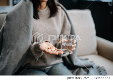 woman holding bottle with pills on hand going to take medicaments prescribed by his physician 134544634