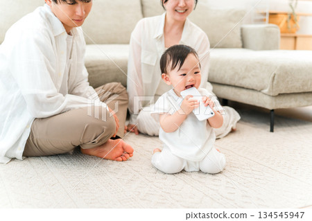 Baby trying to put a smartphone in his mouth in the living room (accidental ingestion, swallowing accident) Baby trying to put a smartphone in his mouth in the living room (accidental ingestion, swallowing accident) 134545947