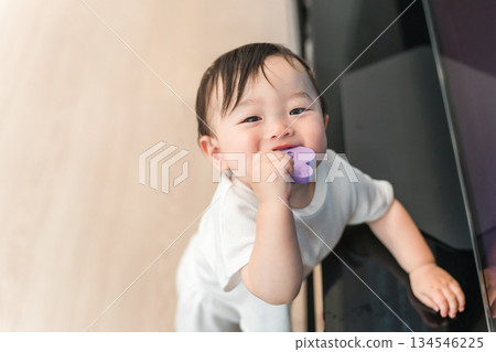 Baby standing up in the living room at home (walking, growth, development) Baby standing up in the living room at home (walking, growth, development) 134546225