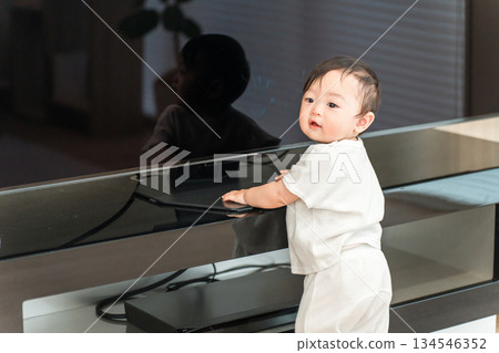 Baby standing up in the living room at home (walking, growth, development) Baby standing up in the living room at home (walking, growth, development) 134546352