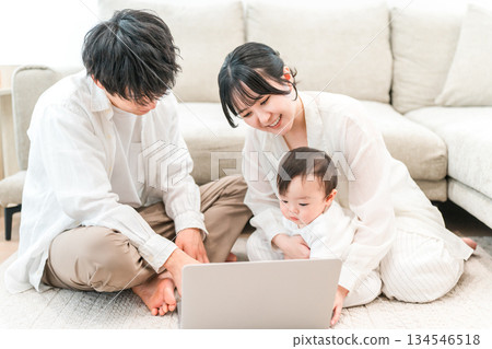 父母在自家客廳和孩子及嬰兒玩耍（電腦、育兒、親子互動） 134546518