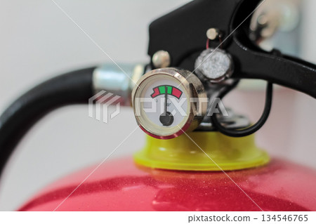 Macro shot of fire extinguisher pressure indicator gauge showing system readiness and operating safety zone 134546765