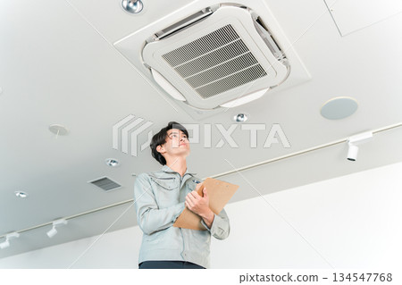 A man in work clothes cleaning and inspecting air conditioners and air conditioning equipment A man in work clothes cleaning and inspecting air conditioners and air conditioning equipment 134547768