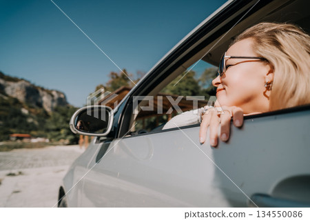 Woman in a Car, Smiling and Looking Out the Window Woman in a Car, Smiling and Looking Out the Window 134550086
