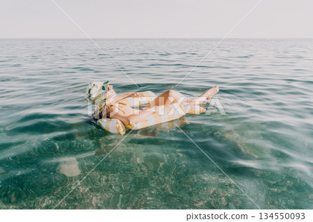 Woman Inflatable Raft Sea Relaxing - A woman relaxes on an inflatable raft in the sea. 134550093