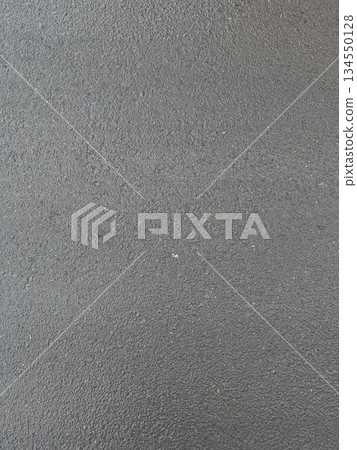 Dark wet asphalt pavement with a rough texture, viewed from above. Outdoor roadway background. Urban construction and road materials concept. Textured photo. 134550128
