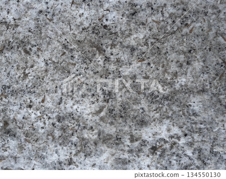 A dirty snowy surface with soil and natural particles, snow-covered asphalt. Textured background, top view. Winter season concept for design. 134550130