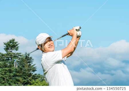 Male golfer playing golf on a golf course (serious, tee shot, golf competition) Male golfer playing golf on a golf course (serious, tee shot, golf competition) 134550725