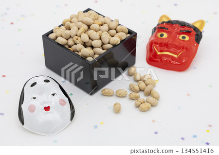 A black masu box placed on a white background, roasted soybeans and red demon and okame masks, an image of Setsubun 134551416