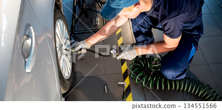 Professional car mechanic working with in auto repair service. Repair of wheels Professional car mechanic working with in auto repair service. Repair of wheels 134551566