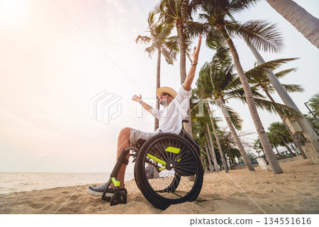 Disabled man in a wheelchair on the beach. Disabled man in a wheelchair on the beach. 134551616