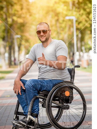 Handicapped man in wheelchair walk at the park alley Handicapped man in wheelchair walk at the park alley 134551623