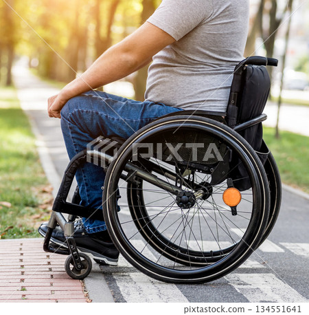 Handicapped man in wheelchair preparing to cross the road on pedestrian crossing Handicapped man in wheelchair preparing to cross the road on pedestrian crossing 134551641