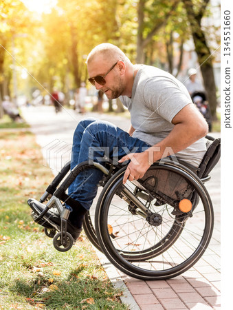 Handicapped man in wheelchair walk at the park alley 134551660