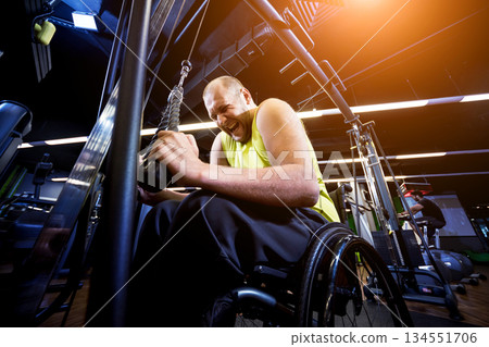 Disabled man training in the gym of rehabilitation center Disabled man training in the gym of rehabilitation center 134551706