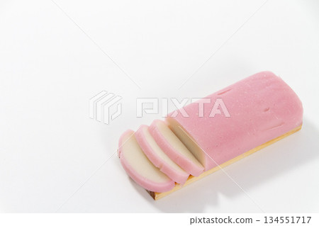Sliced pink kamaboko fish cakes arranged on a white background Sliced pink kamaboko fish cakes arranged on a white background 134551717