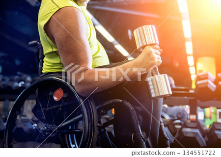 Disabled man training in the gym of rehabilitation center Disabled man training in the gym of rehabilitation center 134551722