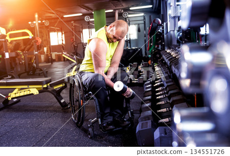Disabled man training in the gym of rehabilitation center Disabled man training in the gym of rehabilitation center 134551726