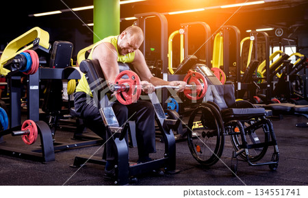 Disabled man training in the gym of rehabilitation center Disabled man training in the gym of rehabilitation center 134551741