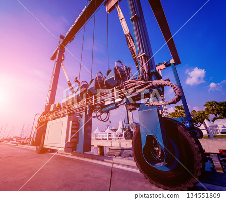 Lifting crane for elevating boat at harbor docks. Lifting crane for elevating boat at harbor docks. 134551809