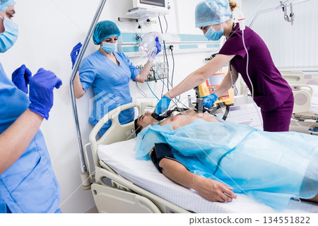 Doctors give resuscitation to a male patient in the emergency room. 134551822