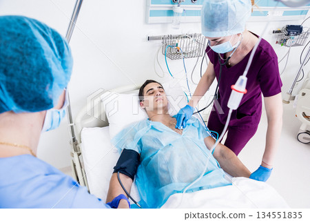 Doctors give resuscitation to a male patient in the emergency room. 134551835