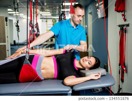 Physiotherapy. Suspension training therapy. Young woman doing fitness traction 134551876