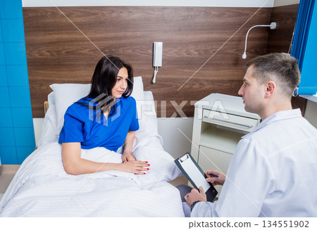 Traumatologist talking with young female patient in modern hospital Traumatologist talking with young female patient in modern hospital 134551902