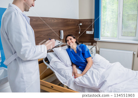 Traumatologist talking with young female patient in modern hospital 134551903