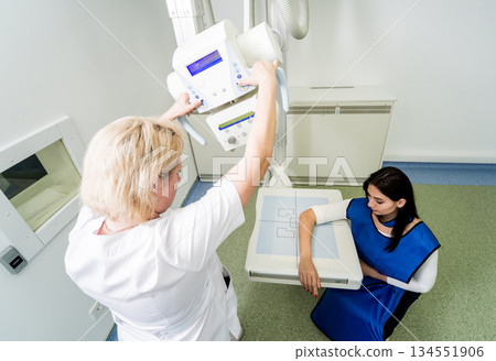 Radiologist and patient in a x-ray room. X-ray of human hand. Radiologist and patient in a x-ray room. X-ray of human hand. 134551906