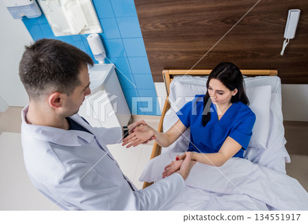 Traumatologist examining patient hands in modern hospital Traumatologist examining patient hands in modern hospital 134551917