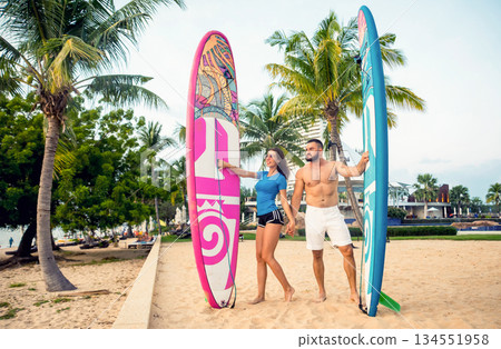 Two young surfers with boards on the beach Two young surfers with boards on the beach 134551958