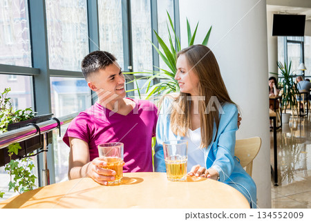 Cheerful couple in the pub. Drinking beer, talking, having fun. Cheerful couple in the pub. Drinking beer, talking, having fun. 134552009