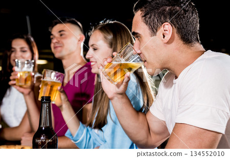 Cheerful friends in the pub. Drinking beer, wine and whisky 134552010