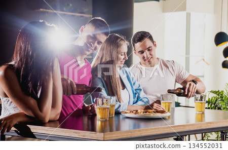 Cheerful friends in the pub. Drinking beer, wine and whisky 134552031