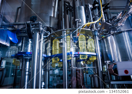 Bottling line of sunflower oil in bottles. Vegetable oil production plant. Bottling line of sunflower oil in bottles. Vegetable oil production plant. 134552061